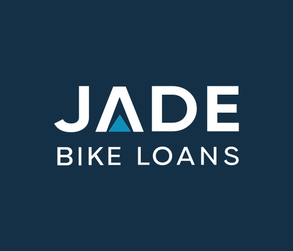 A black motorcycle in a dark room with an illuminated white jagged line on the wall in the background pointing downwards to illustrate lower interest rates on new motorcycles in 2025
